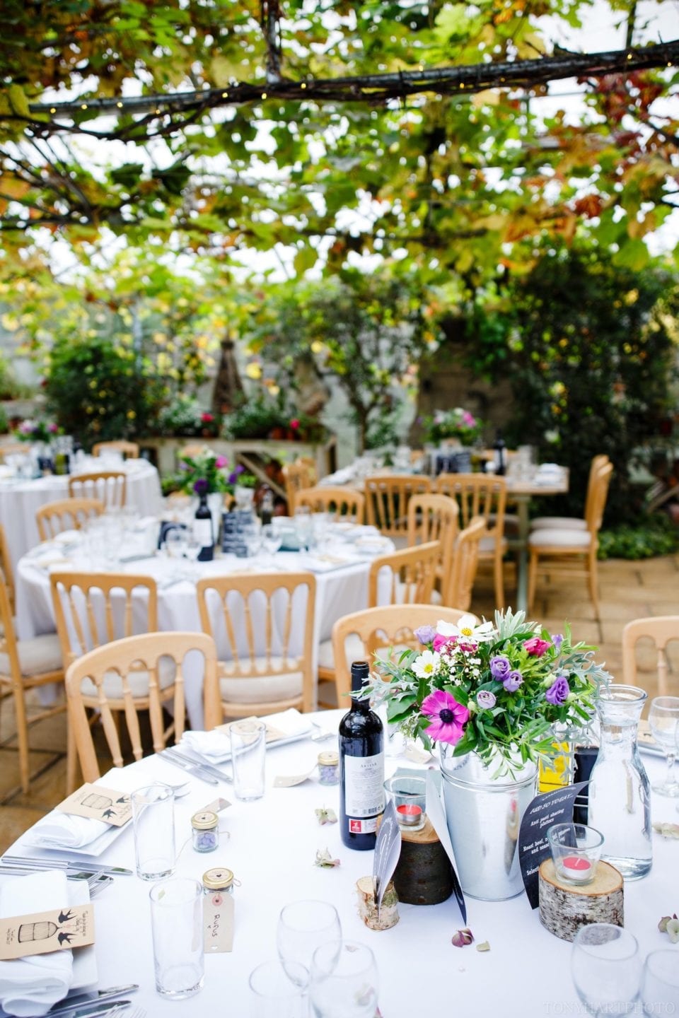 Wedding breakfast tables in the Greenhouse during Emma & Tom's beautiful West Green House wedding