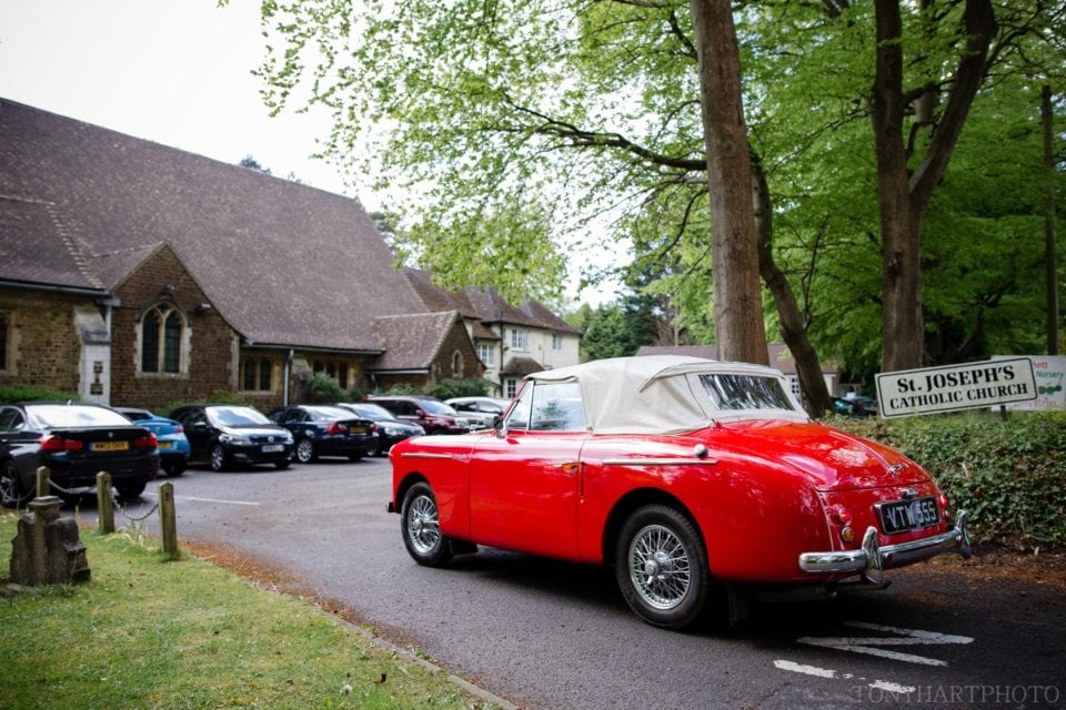 Red vintage wedding car arrives