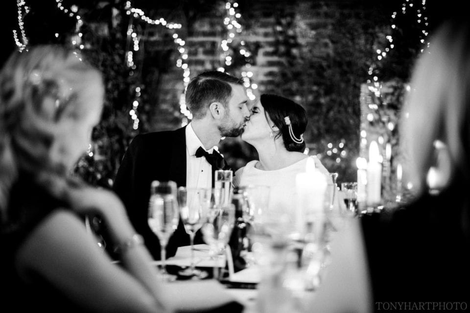 Northbrook Park Wedding Photography - Bride and Groom share a kiss following the wedding speeches
